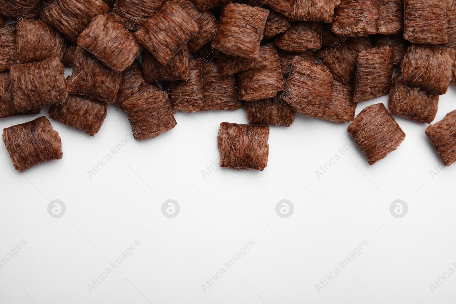 Photo of Chocolate cereal pads on white background, flat lay. Space for text