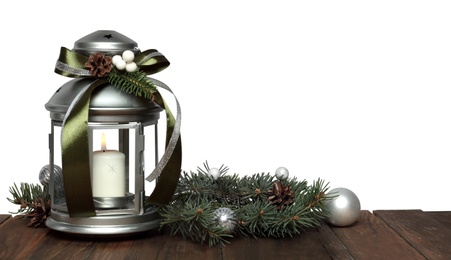 Photo of Christmas lantern, fir branch with balls on wooden table, space for text