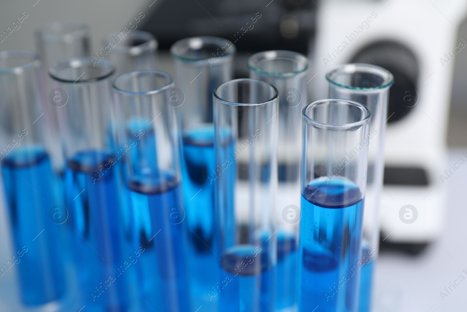 Photo of Laboratory analysis. Test tubes with blue liquid on table, closeup