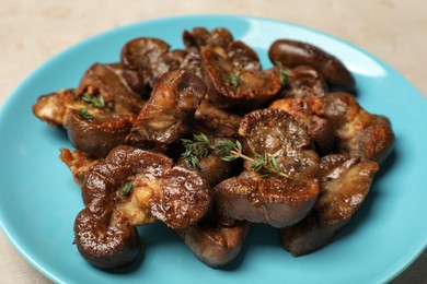 Plate with delicious kidneys and thyme on light table, closeup