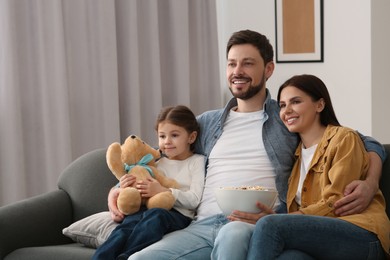 Photo of Happy family watching TV on sofa at home