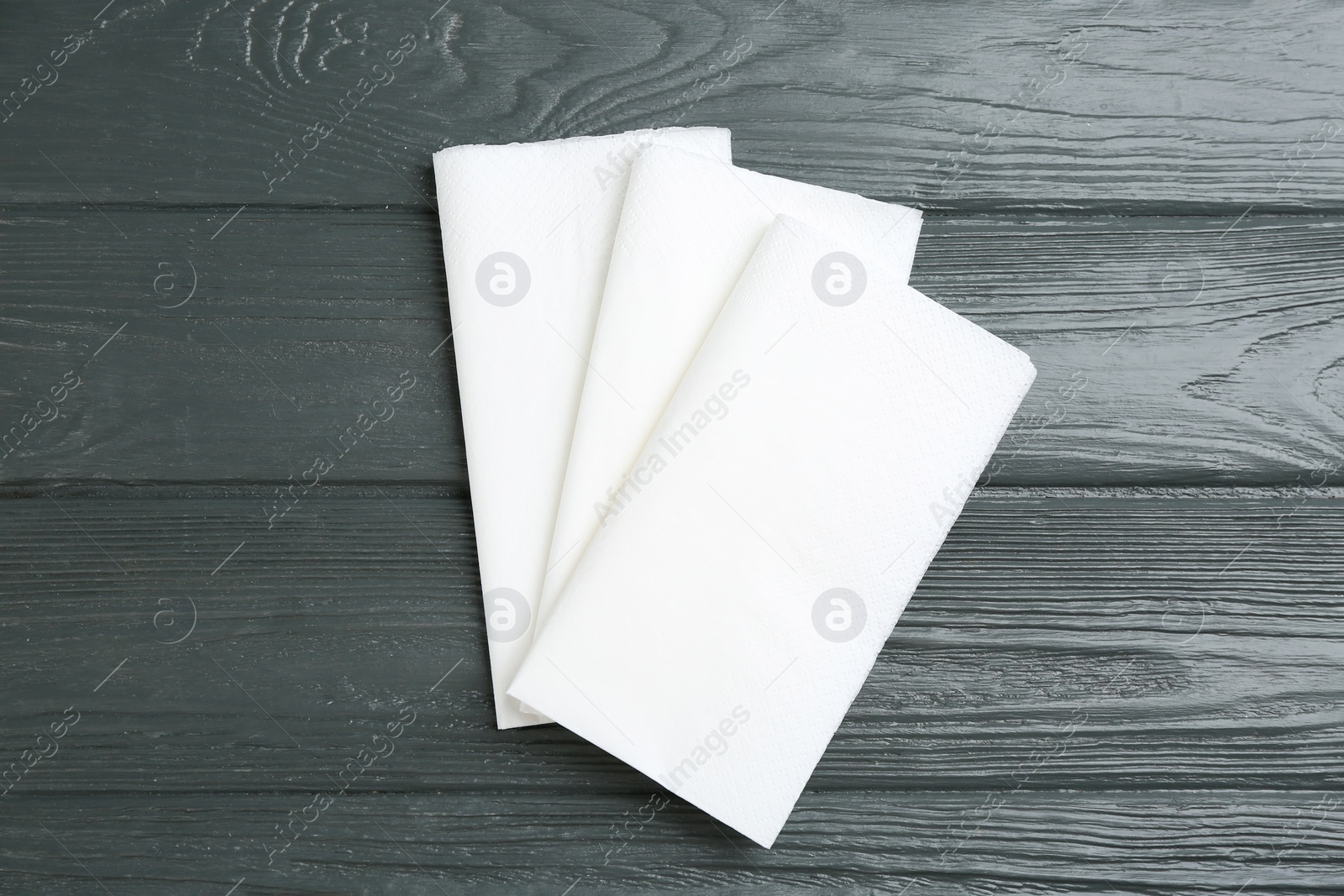 Photo of Clean napkins on grey wooden table, flat lay