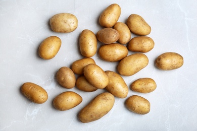 Photo of Fresh ripe organic potatoes on grey background, top view