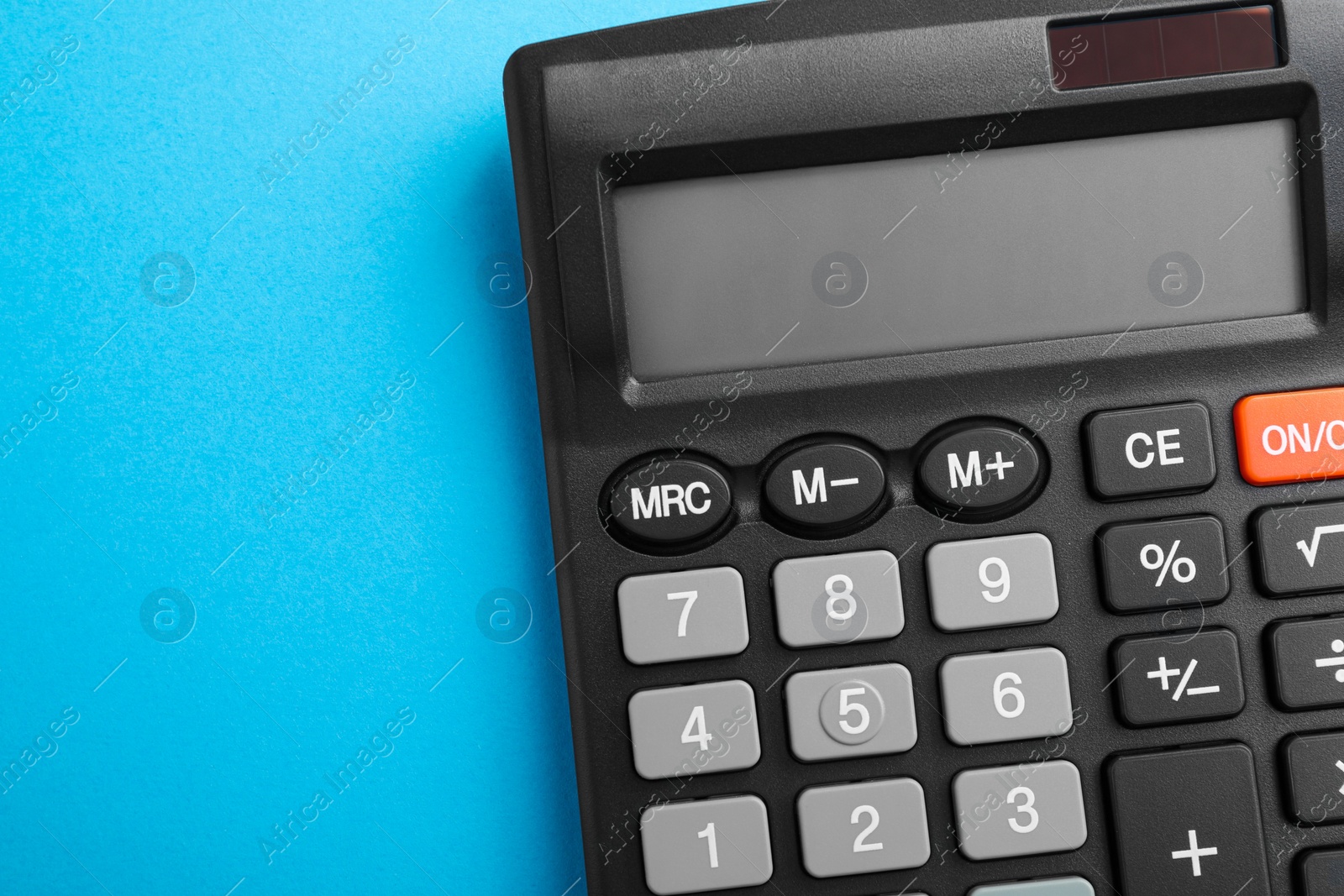 Photo of Calculator on light blue background, top view. Space for text