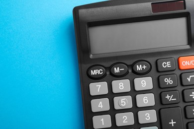 Calculator on light blue background, top view. Space for text