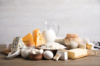 Photo of Different delicious dairy products on wooden table