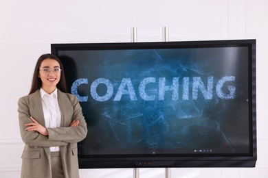 Business trainer near interactive board in meeting room