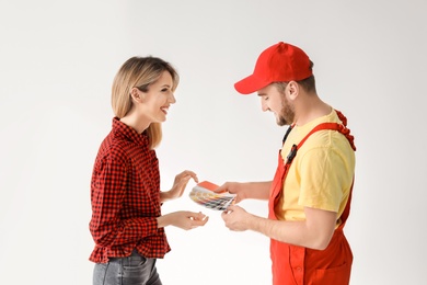 Photo of Male decorator and young woman with color palette on white background