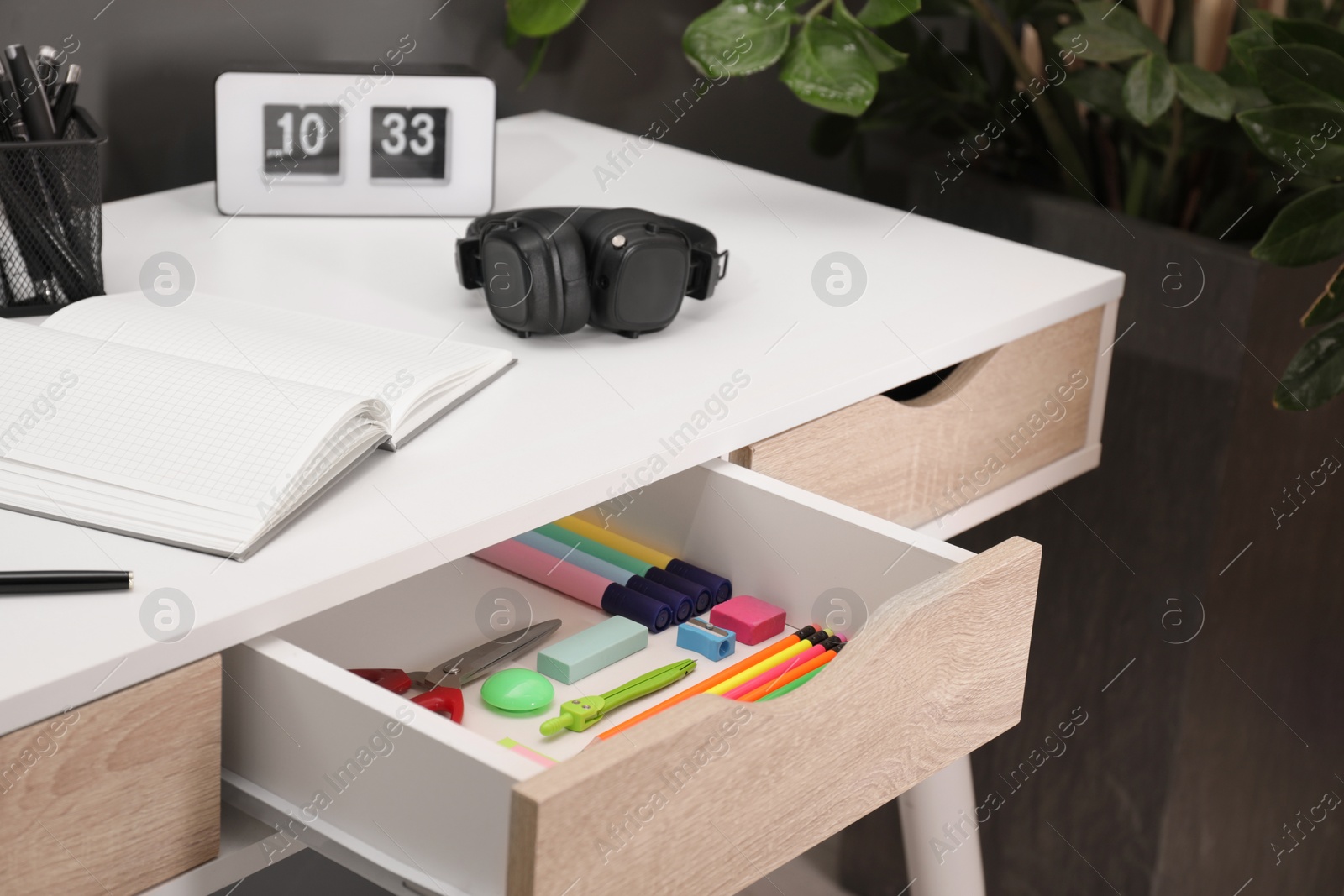 Photo of Office supplies in open desk drawer indoors