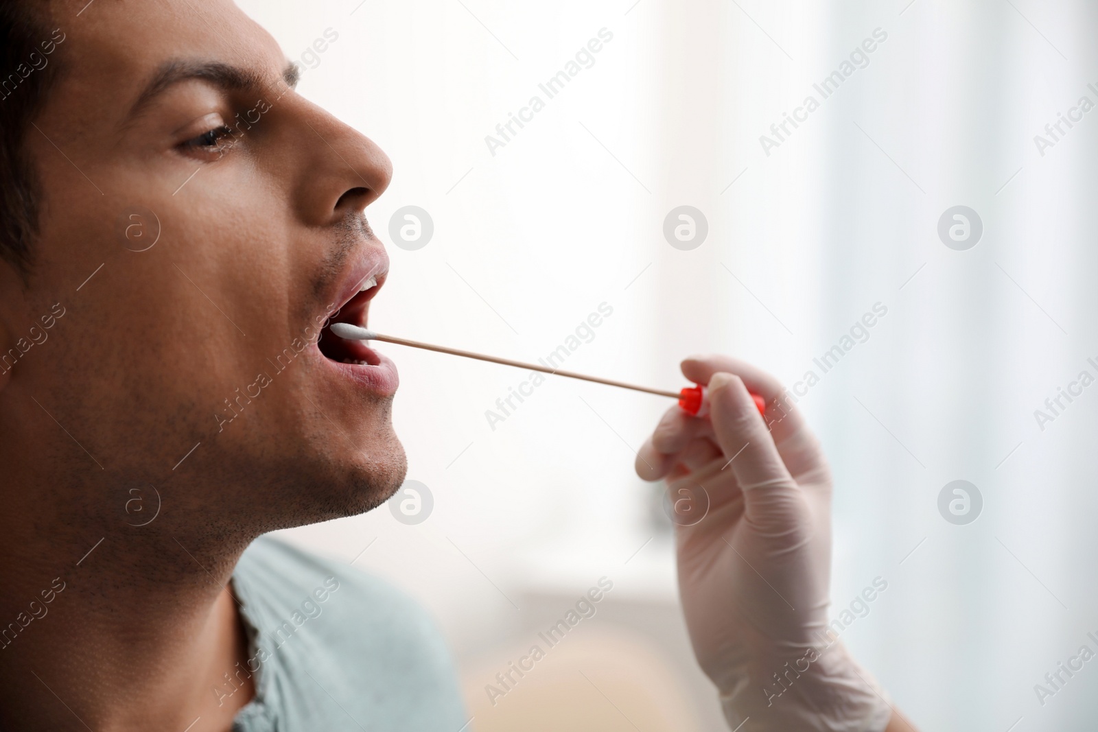 Photo of Doctor taking sample for DNA test from man in clinic