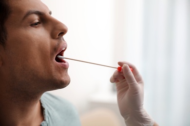 Photo of Doctor taking sample for DNA test from man in clinic