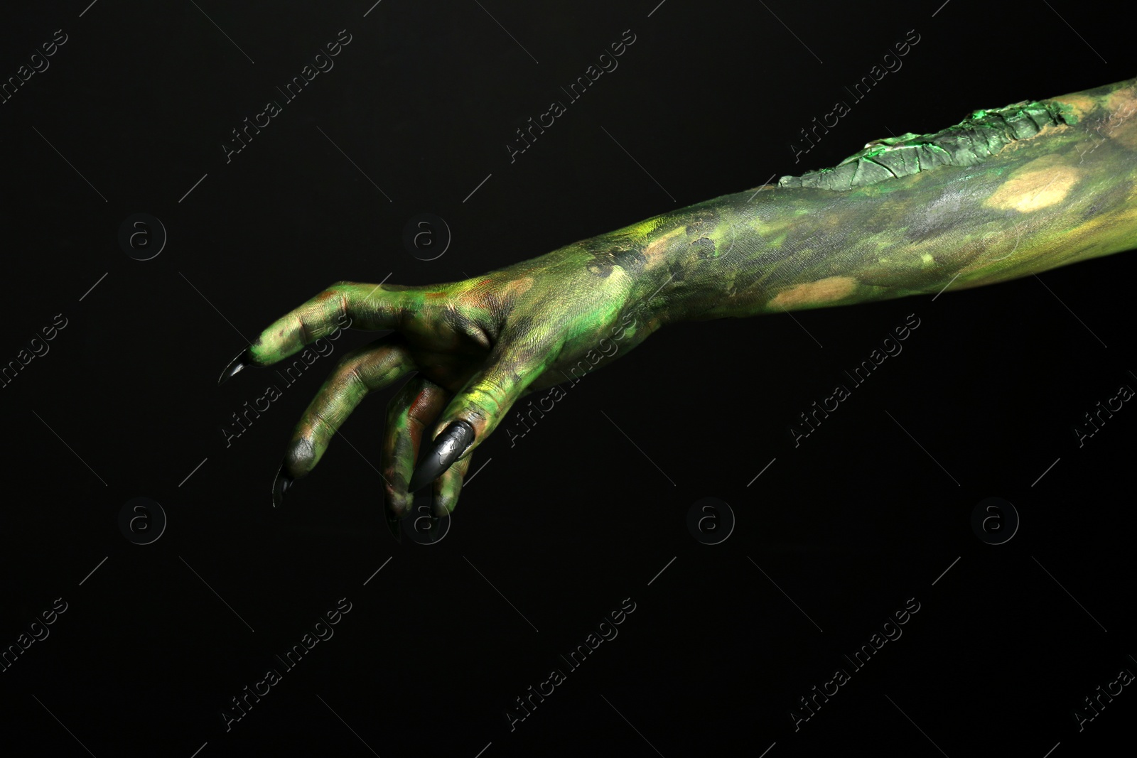 Photo of Scary monster on black background, closeup of hand. Halloween character