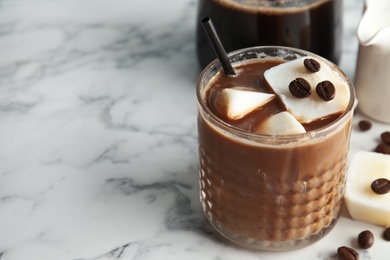 Photo of Coffee cocktail with milk ice cubes on marble table. Space for text