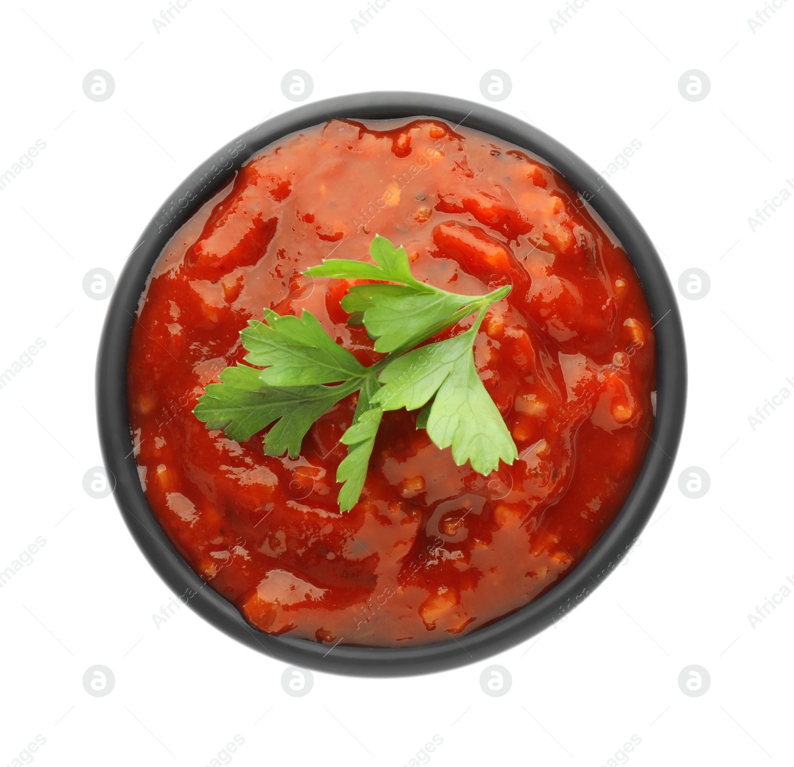 Photo of Delicious adjika sauce and parsley in bowl isolated on white, top view