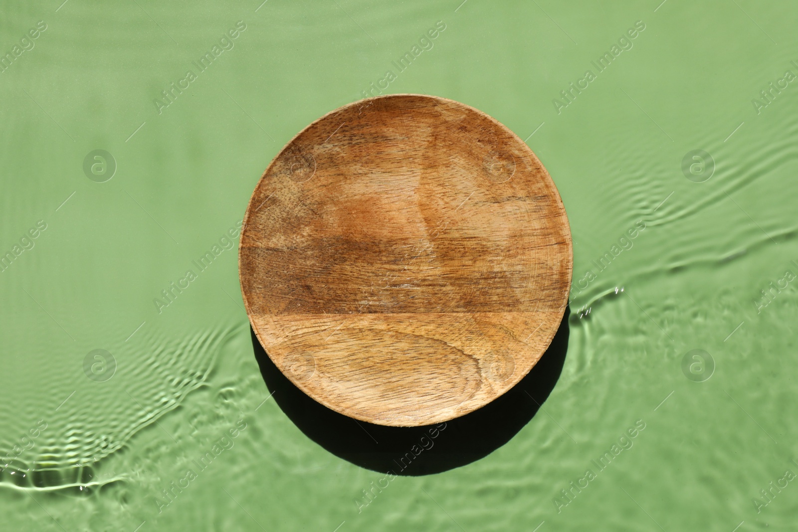 Photo of Presentation for product. Wooden podium in water on green background, top view