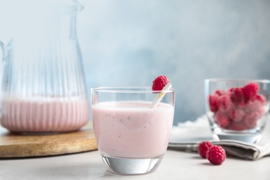 Photo of Tasty fresh milk shake with raspberry on white table