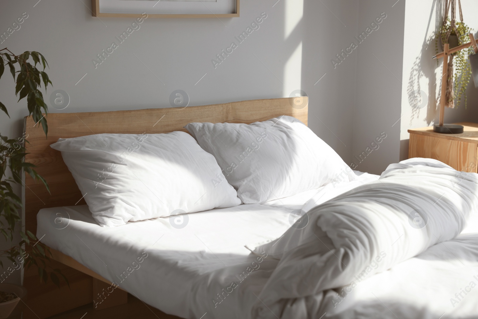 Photo of Large comfortable bed with soft pillows and blanket indoors