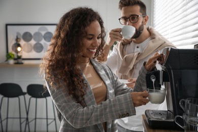African American woman preparing fresh aromatic coffee with modern machine in office