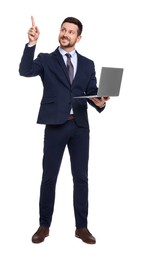 Handsome bearded businessman in suit with laptop pointing at something on white background