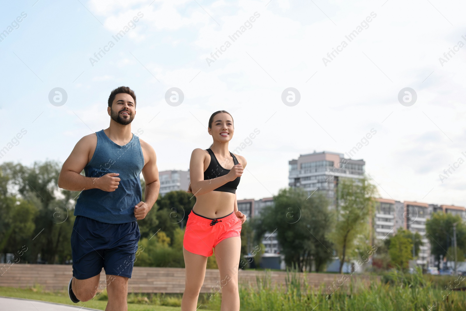 Photo of Healthy lifestyle. Happy couple running outdoors, space for text