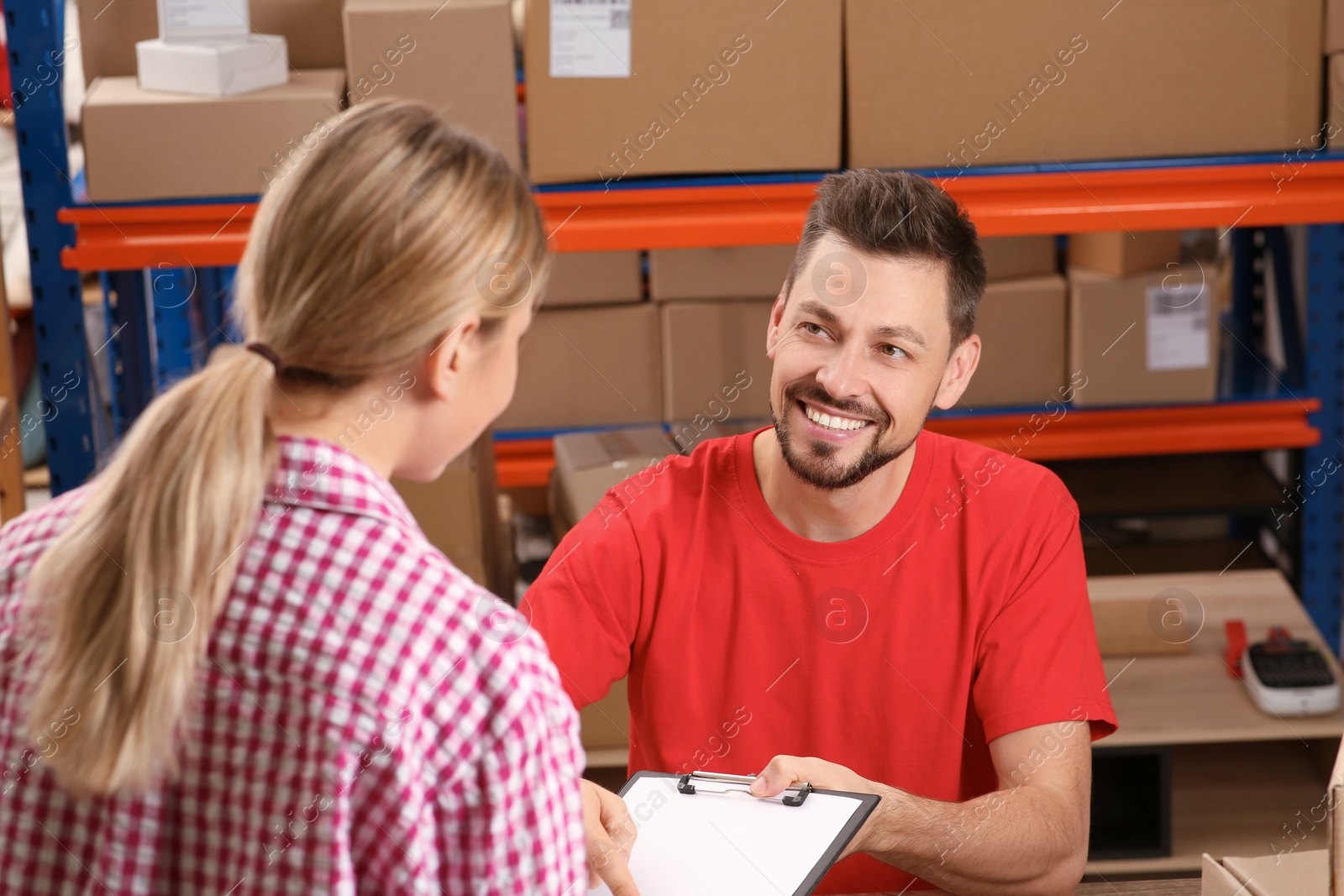 Photo of Woman signing papers for delivered parcel at post office