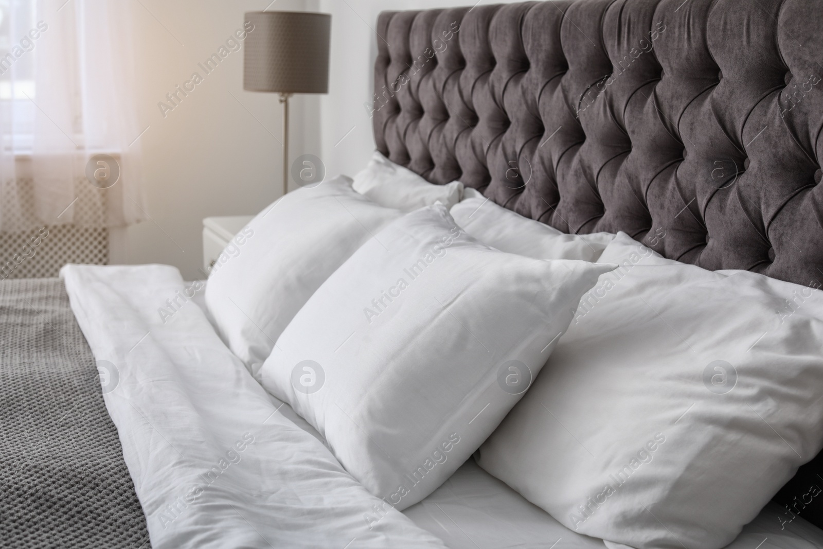 Photo of Soft white pillows on comfortable bed indoors