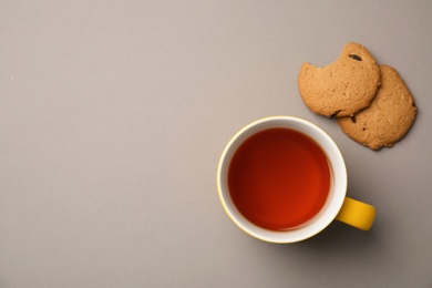 Photo of Cup of black tea with cookies on color background, top view