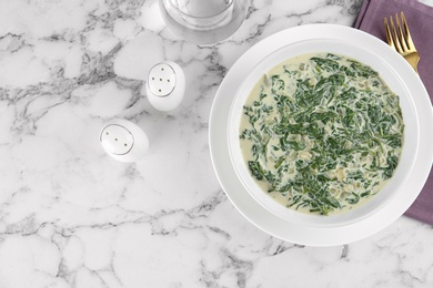 Photo of Tasty spinach dip on white marble table, flat lay