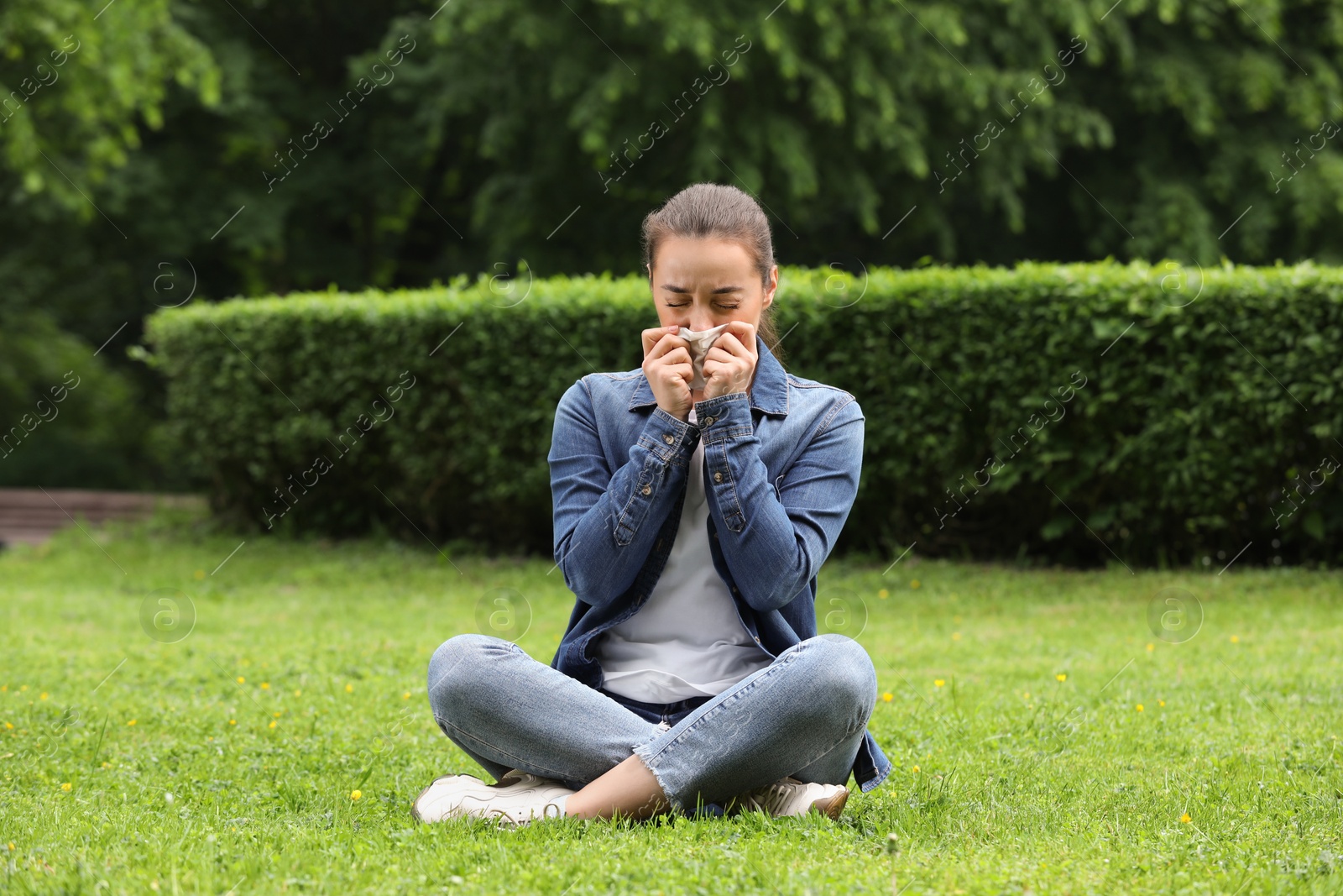 Photo of Woman suffering from seasonal spring allergy on green grass in park