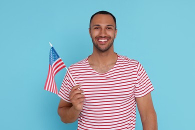 4th of July - Independence Day of USA. Happy man with American flag on light blue background