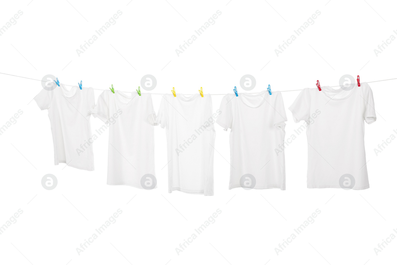 Photo of Many t-shirts drying on washing line isolated on white