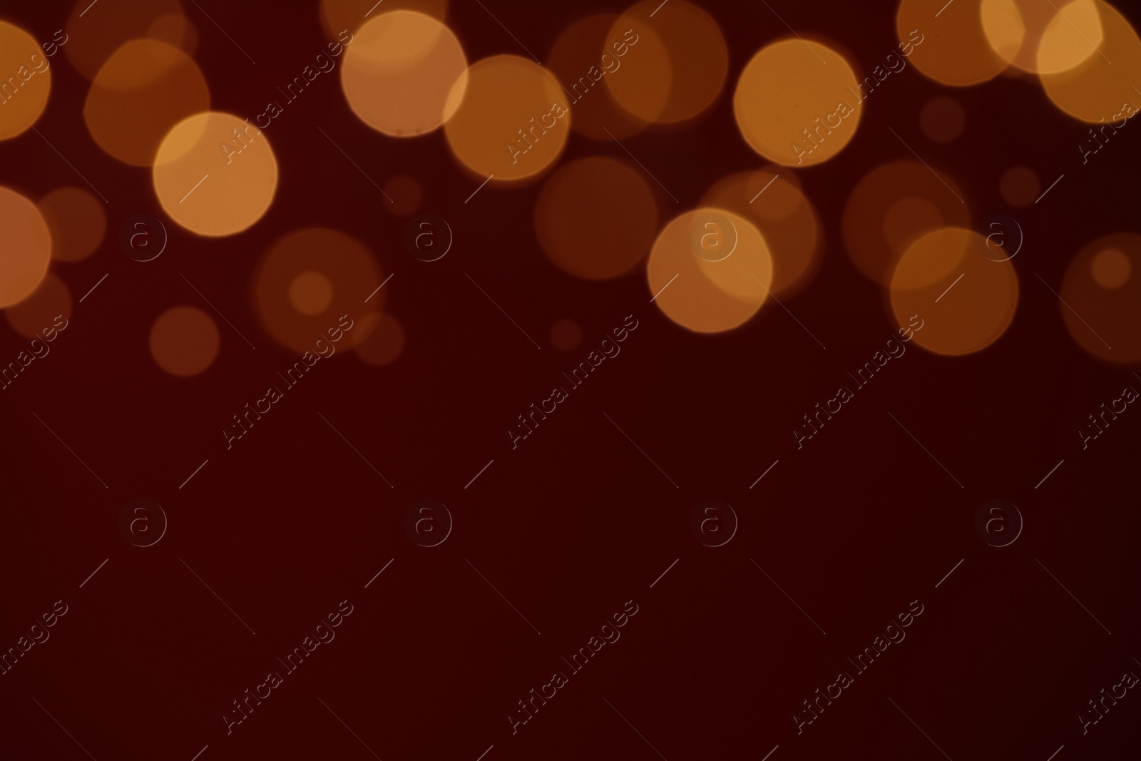 Photo of Blurred view of festive lights on red background, space for text. Bokeh effect