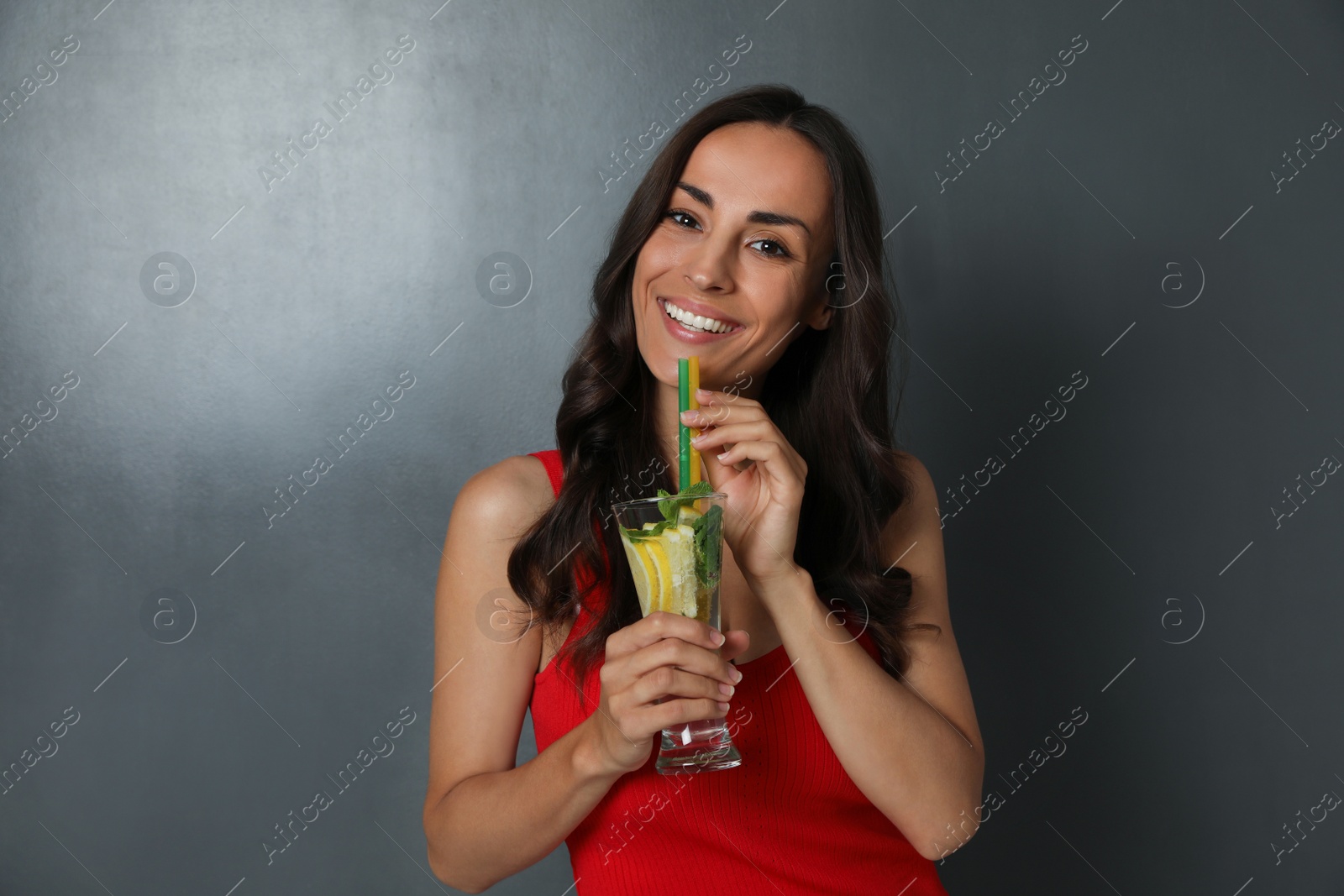 Photo of Young woman with refreshing drink on dark grey background