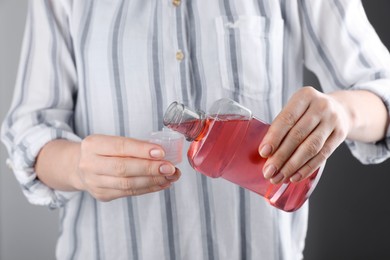 Woman pouring mouthwash from bottle into lid, closeup