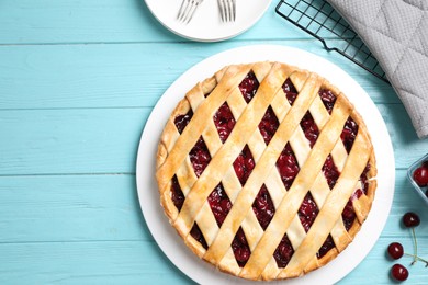 Photo of Flat lay composition with tasty cherry pie on light blue wooden table