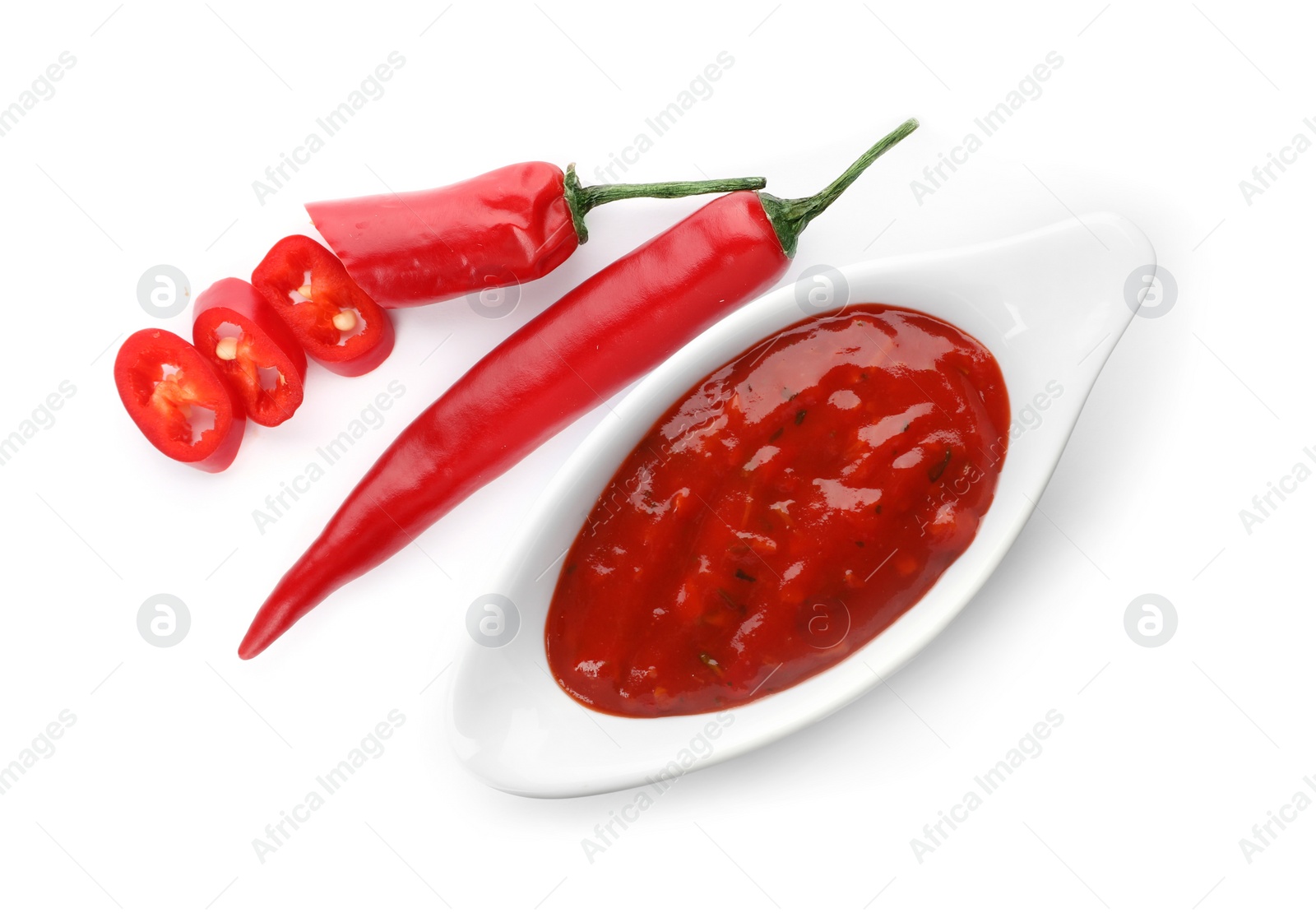 Photo of Gravy boat with spicy chili sauce and fresh pepper on white background, top view
