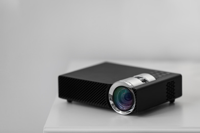 Modern video projector on white table indoors
