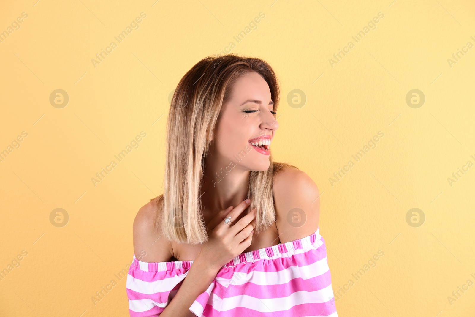 Photo of Portrait of beautiful laughing woman on color background