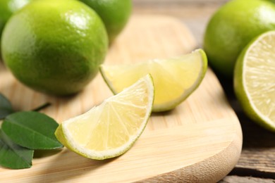 Photo of Whole and cut fresh limes on table, closeup