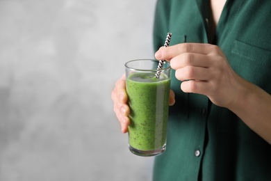 Woman with delicious kiwi smoothie on blue background, closeup. Space for text