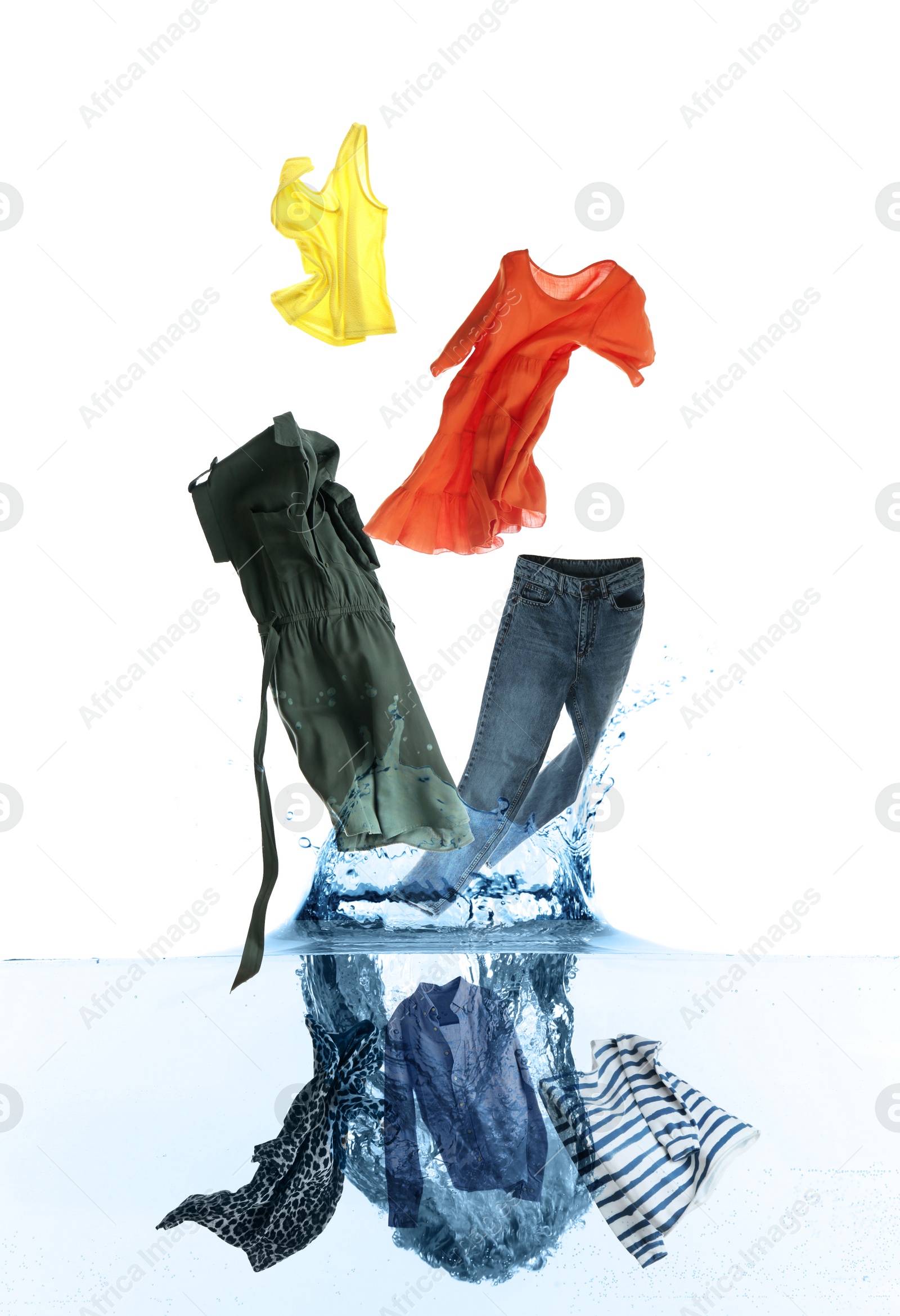 Image of Different clothes falling into water against white background