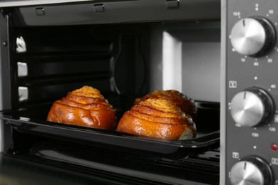 Photo of Open electric oven with delicious pastry, closeup