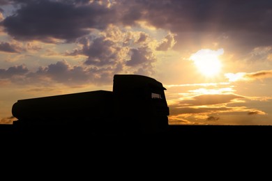 Truck parked on country road at sunset