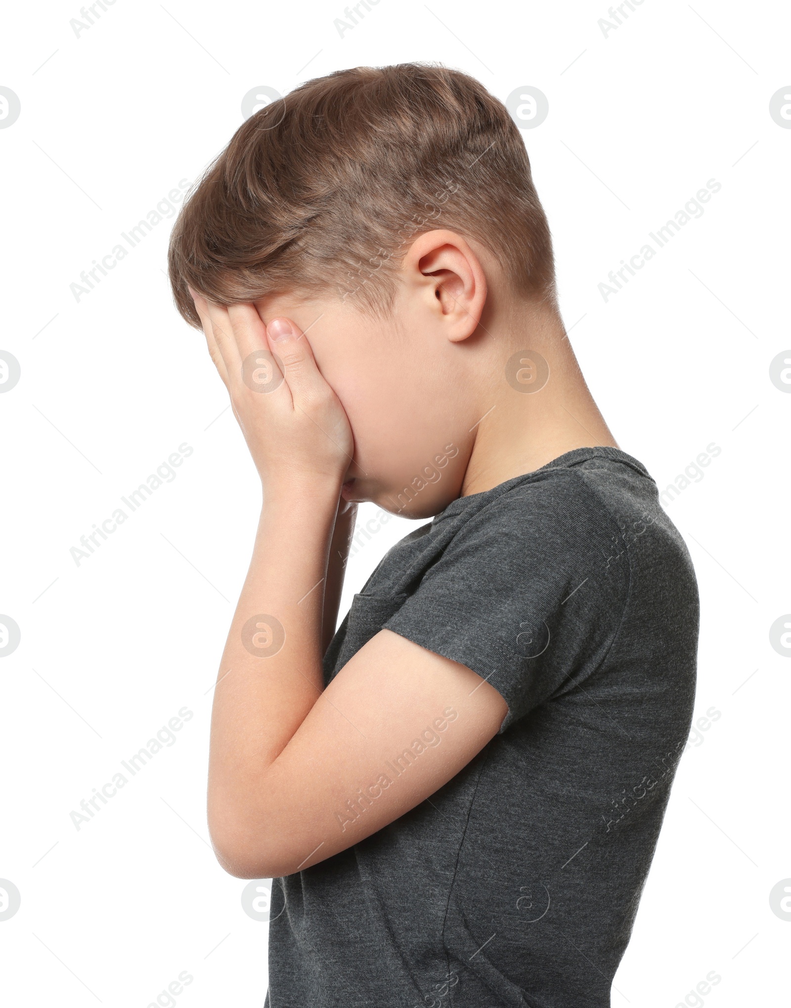 Photo of Boy covering face with hands on white background. Children's bullying