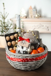 Wicker basket with Christmas gift set on wooden table