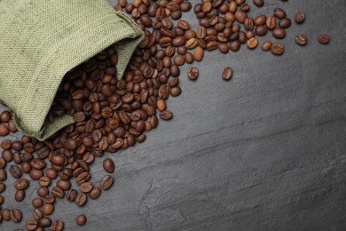 Photo of Bag with roasted coffee beans on black table, flat lay. Space for text