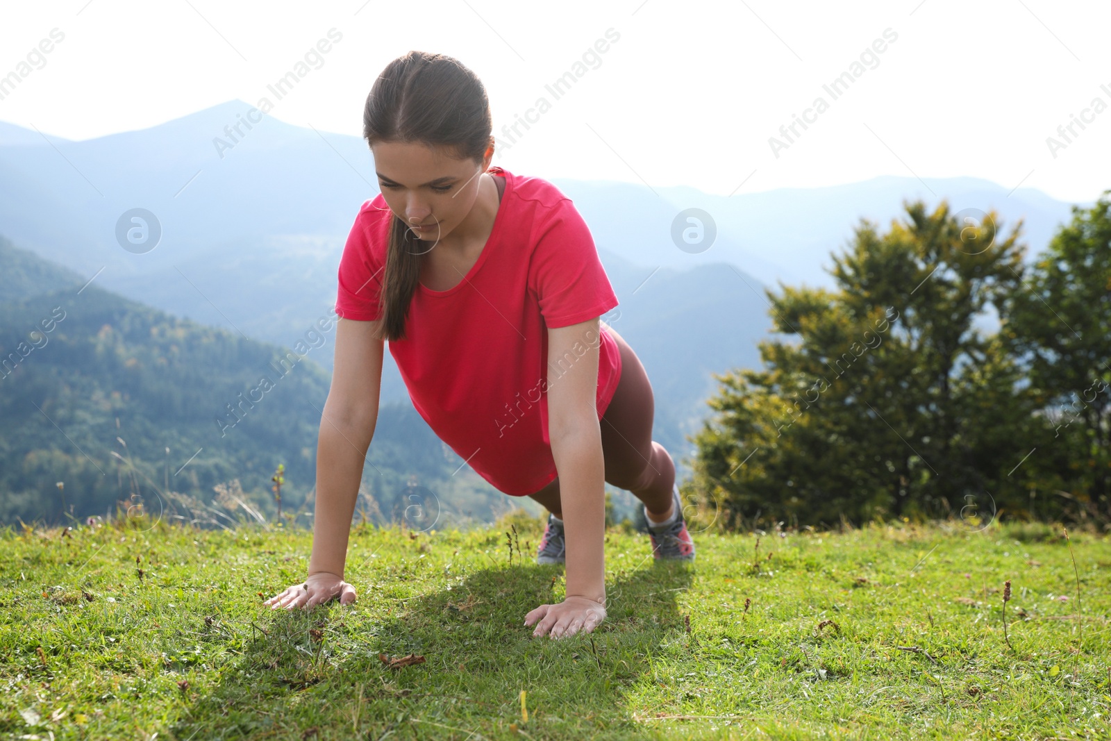 Photo of Young woman doing morning exercise in mountains