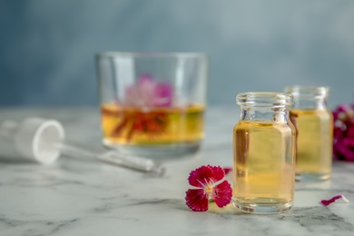 Photo of Composition with essential oils and flowers on table