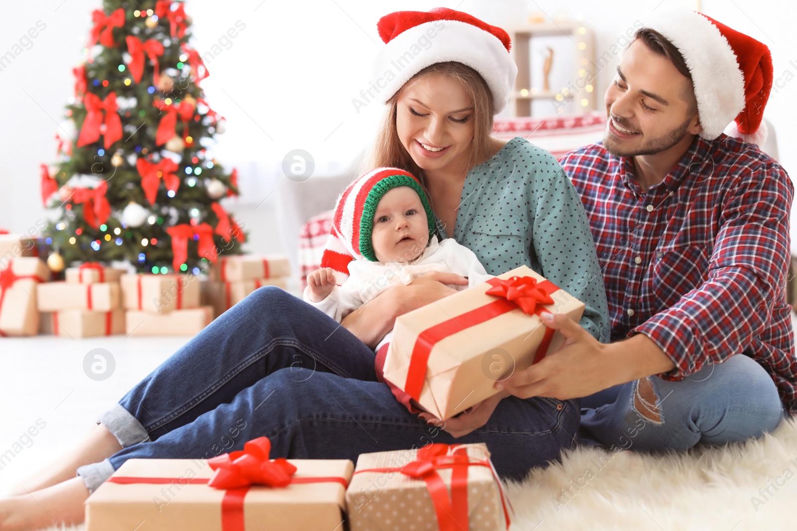 Photo of Happy couple with baby celebrating Christmas together at home