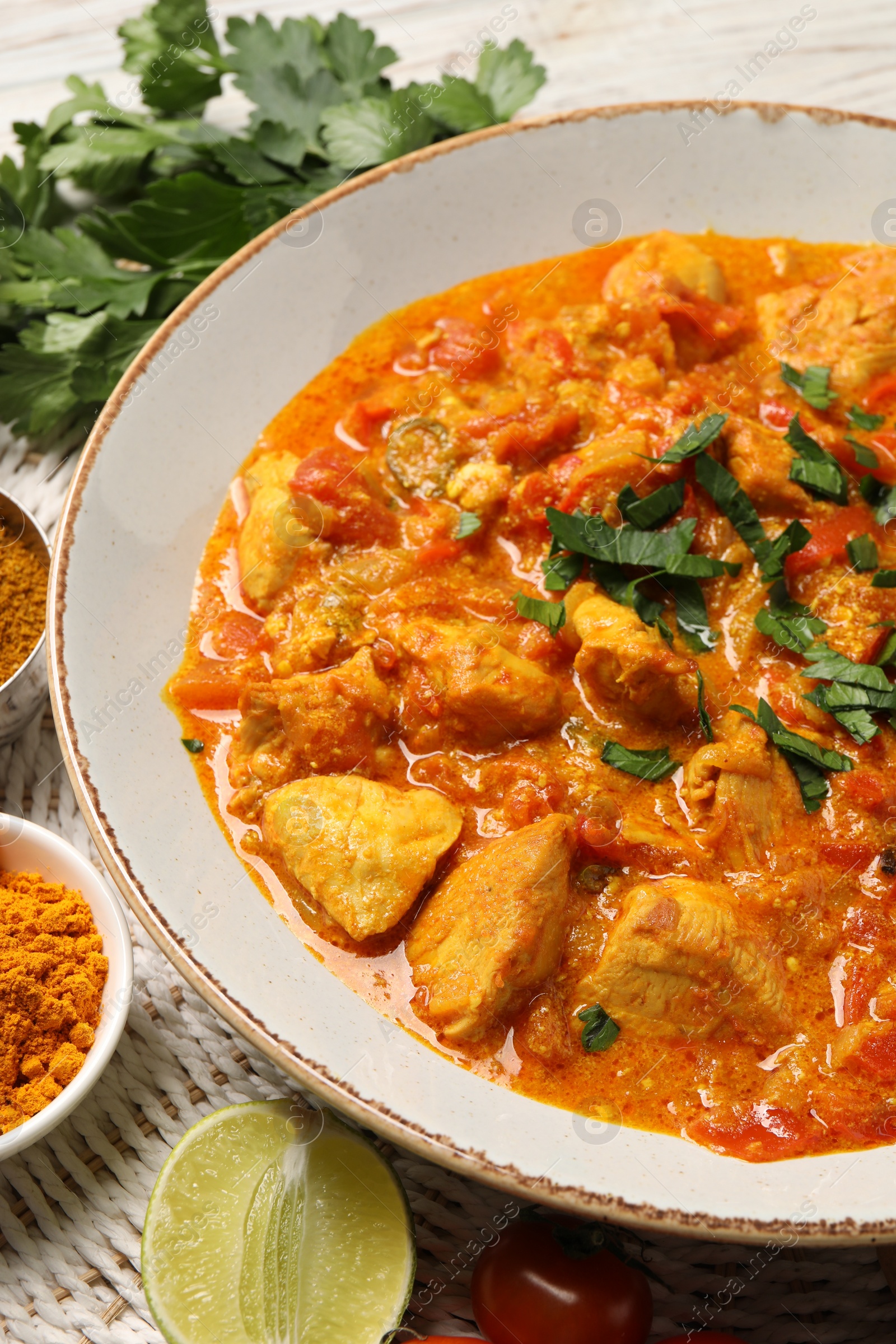 Photo of Delicious chicken curry and ingredients on table